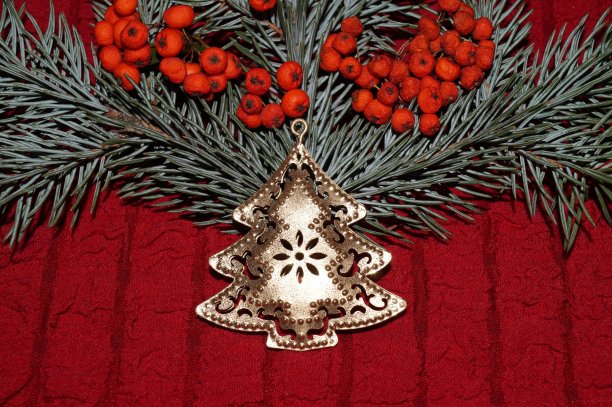 圣诞节用金色的圣诞树、红色的浆果和冷杉树枝布置图片下载