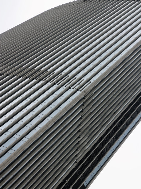 倾斜的摩天大楼在灰色的阴天图片下载