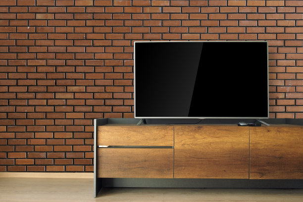 红色砖墙的房间里有Led电视。图片下载