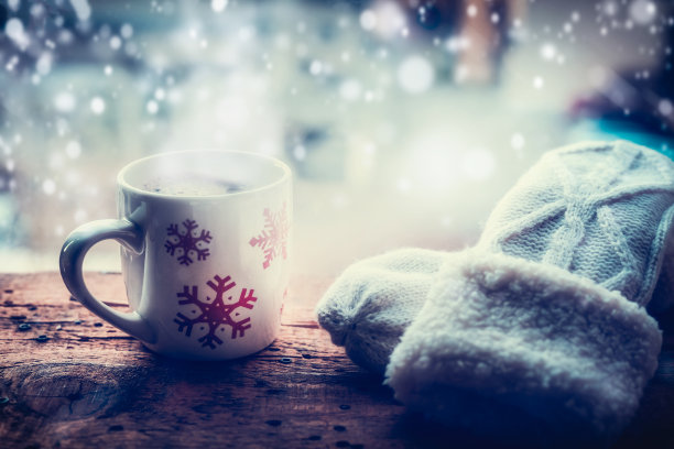 窗台上放着雪花杯，热饮和手套图片下载