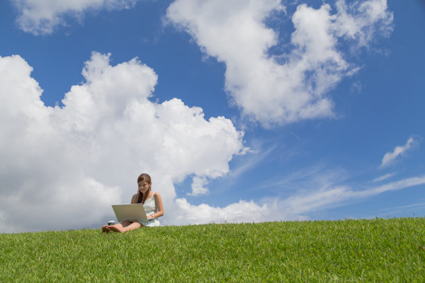 在公园旁边操作个人电脑的年轻女子图片下载