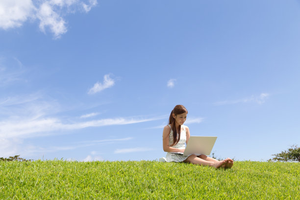 在公园旁边操作个人电脑的年轻女子图片下载