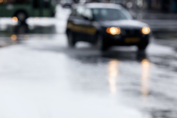 下雨时在潮湿的街道上行驶的汽车模糊不清图片下载