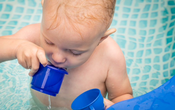 婴儿在游泳池里喝水图片下载