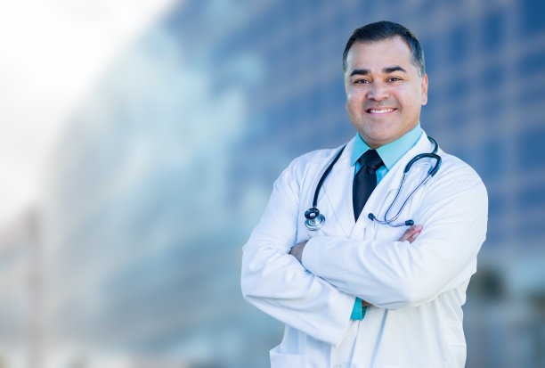 西班牙裔男医生或护士在医院大楼前图片下载