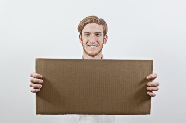 年轻的成年人拿着一个大纸板题词图片下载