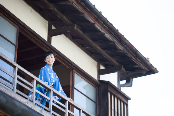 穿着传统服装的妇女站在阳台上图片下载
