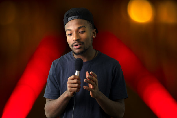 年轻歌手在舞台上，麦克风和红灯设置图片下载