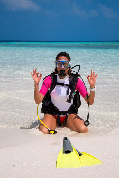 女潜水员在海滩上做OK的标志图片下载