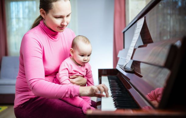 妈妈和宝贝女儿在家里弹钢琴图片下载