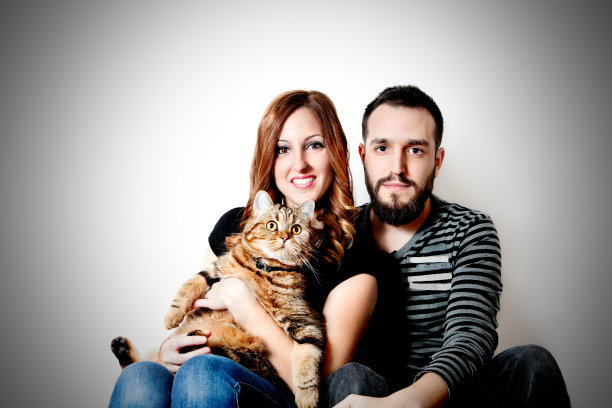 年轻快乐地与你的猫在家里夫妇，宠物图片下载
