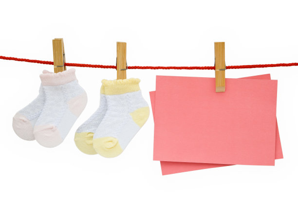 婴儿袜子和空白的纸条挂在小路上剪着图片下载