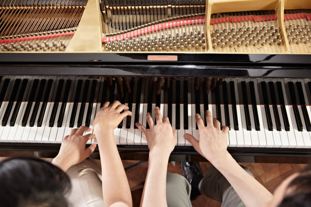 两个人穿着卡其裤一起弹钢琴图片下载