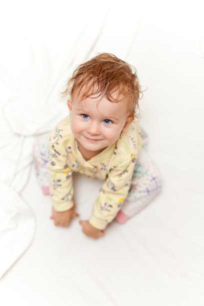 快乐的小女孩坐在床上图片下载