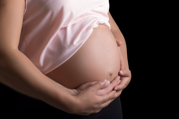 男人和孕妇爱抚着她的肚子图片下载