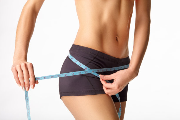 年轻的运动女孩测量腰围图片下载