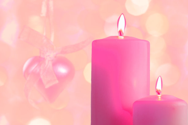 模糊的节日背景上点燃的粉色蜡烛图片下载