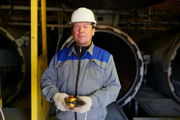 一个戴着遥控器的头盔的工厂工人图片下载