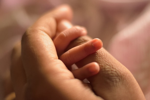 新生婴儿的手抓着母亲的手指图片下载