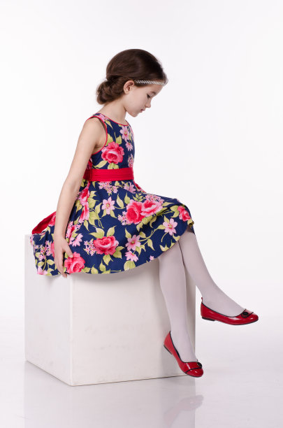 小女孩穿着白色背景上有孤立花朵的连衣裙图片下载