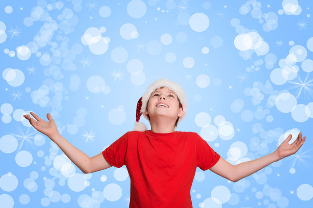 快乐的男孩举起手等待圣诞节。圣诞节期。图片下载