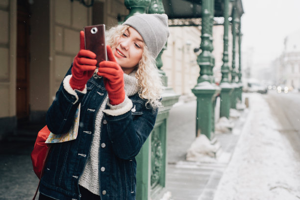 年轻的金发卷毛女游客在街上自拍图片下载