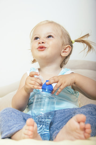 微笑的小女孩拿着一瓶水素材图片