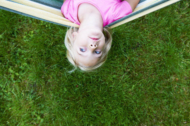 小女孩在夏日花园的吊床上放松图片下载
