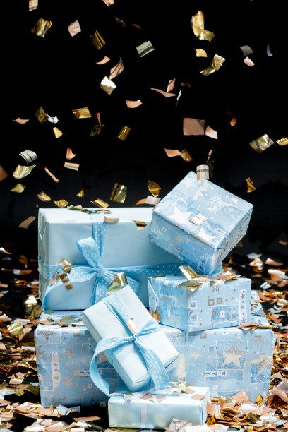 礼品盒和五彩纸屑。黑色背景。图片下载