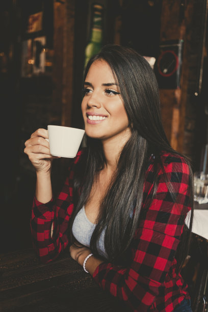 年轻女子微笑着喝着咖啡图片下载