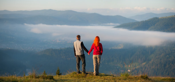 后视图夫妇享受晨雾在山上图片下载