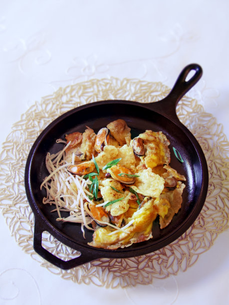 泰国贻贝煎蛋卷在一个铸铁平底锅垂直图片下载