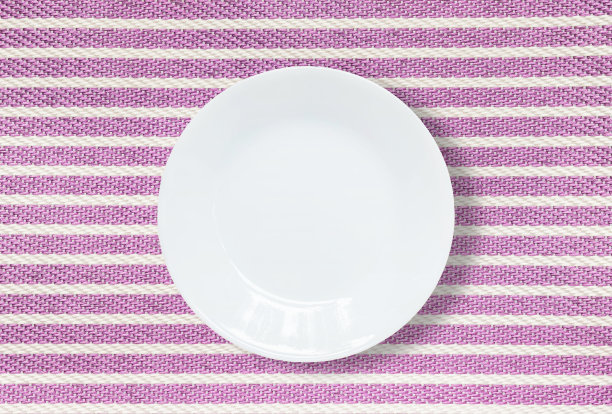 特写白色陶瓷碟上的紫色织物垫子纹理的背景图片下载