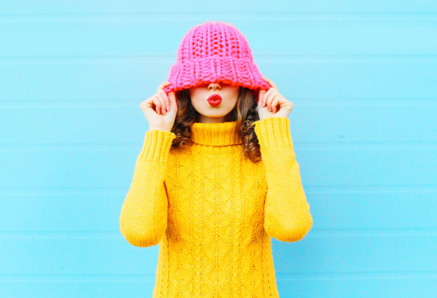 时尚快乐女人吹红唇戴针织帽图片下载