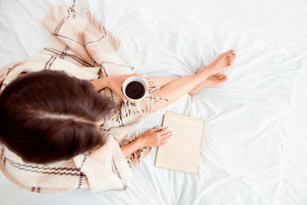 俯视图的女人阅读与格子和咖啡图片下载