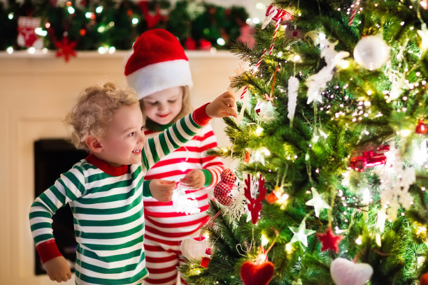 圣诞树下穿着红绿条纹睡衣的孩子们图片下载