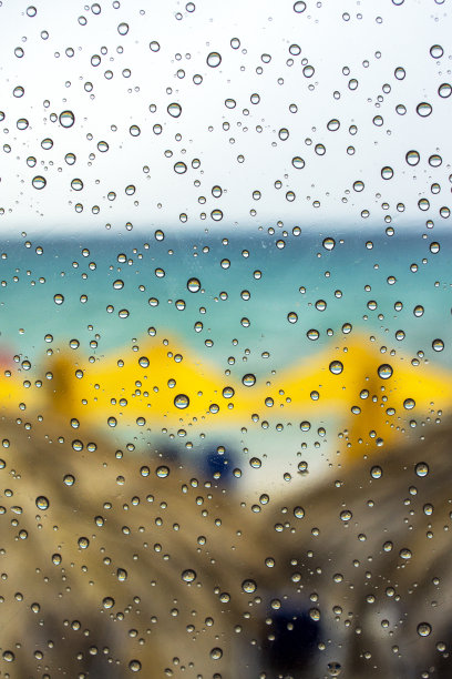雨水滴在玻璃表面的海滩背景图片下载