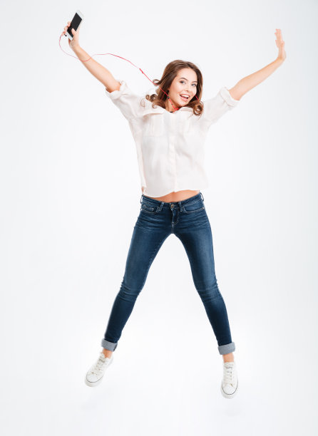 美丽的年轻女孩听着音乐耳机和智能手机图片下载