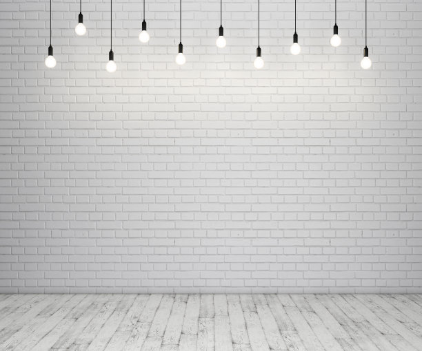 粉刷过的砖墙和木质地板上有发光的灯泡素材图片