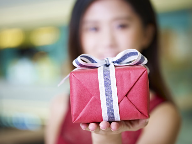 年轻的亚洲女子展示包装好的礼物素材图片