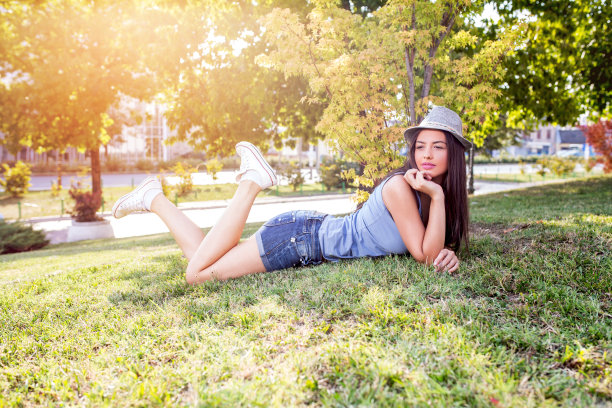 躺在草地上沉思的女人。图片下载