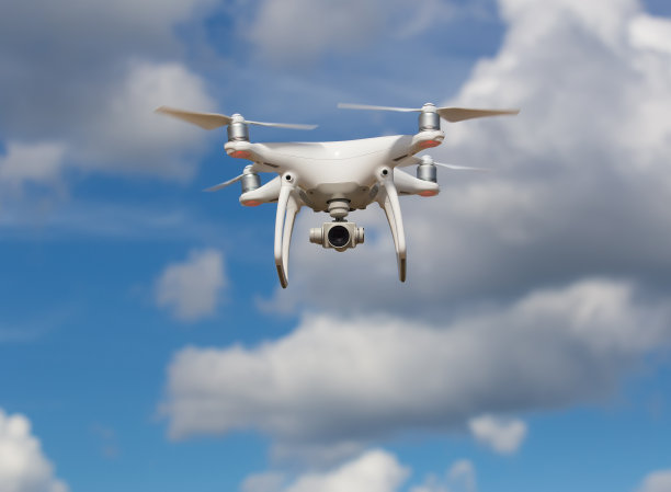 在蓝天上飞行的四轴飞行器图片下载