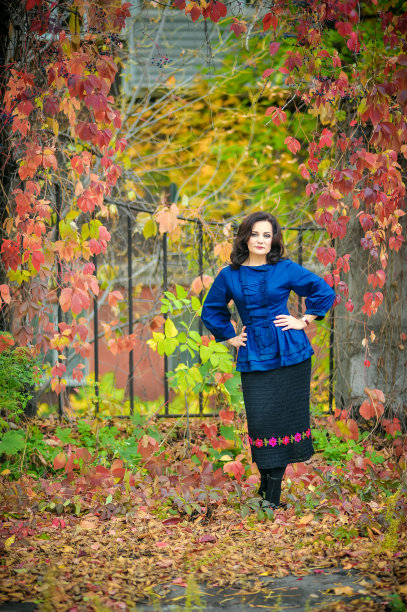 穿着蓝色衬衫的漂亮女人在秋天的公园里图片下载