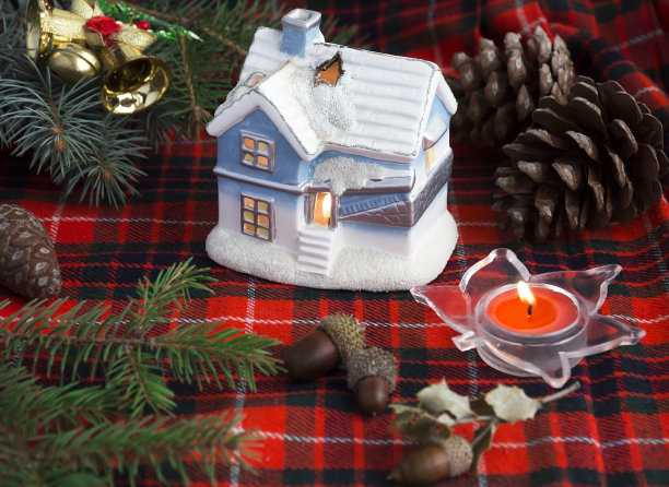 格子图案背景上的烛台、蜡烛和针叶树枝图片下载