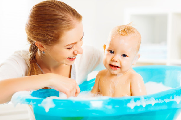 幸福的家庭妈妈在沐浴中给宝宝洗澡图片下载