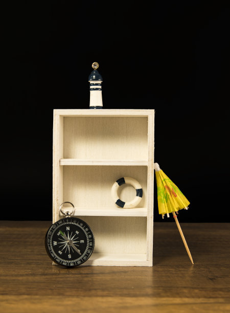 木制的白色架子上装饰着指南针、救生圈和灯塔图片下载