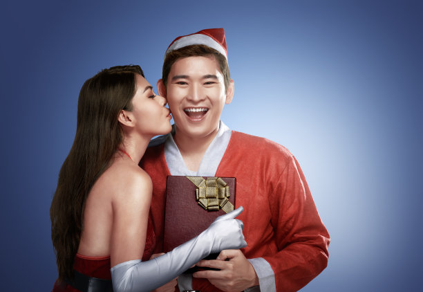 性感的亚洲女孩亲吻她的男友在圣诞节素材图片