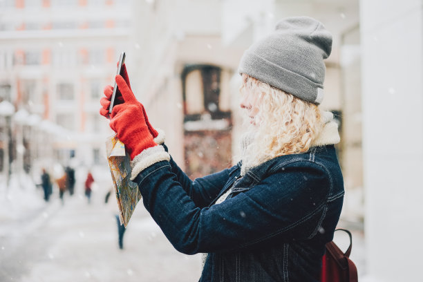 年轻的金发卷毛女孩在用智能手机拍照图片下载