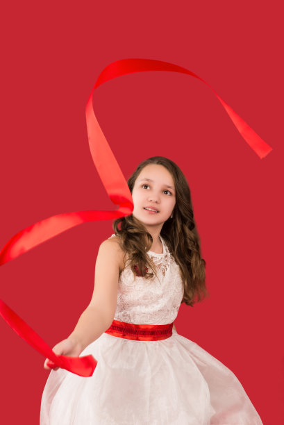 少女抛掷彩带，孤立在红色上图片下载