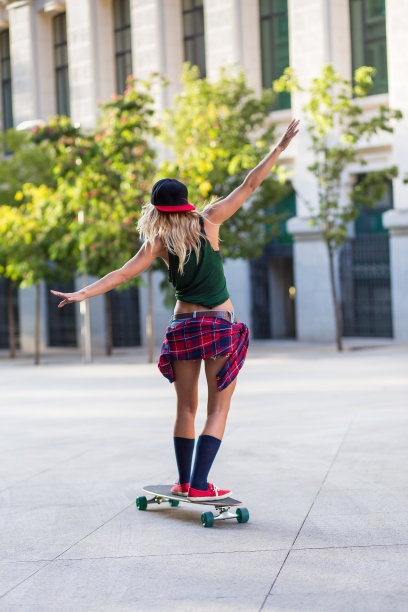 迷人的年轻女人骑着滑板图片下载
